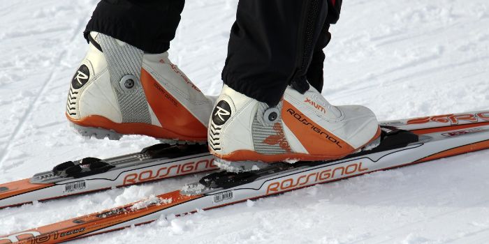 Langlaufski auf Schnee und jemand steigt gerade in die Bindung