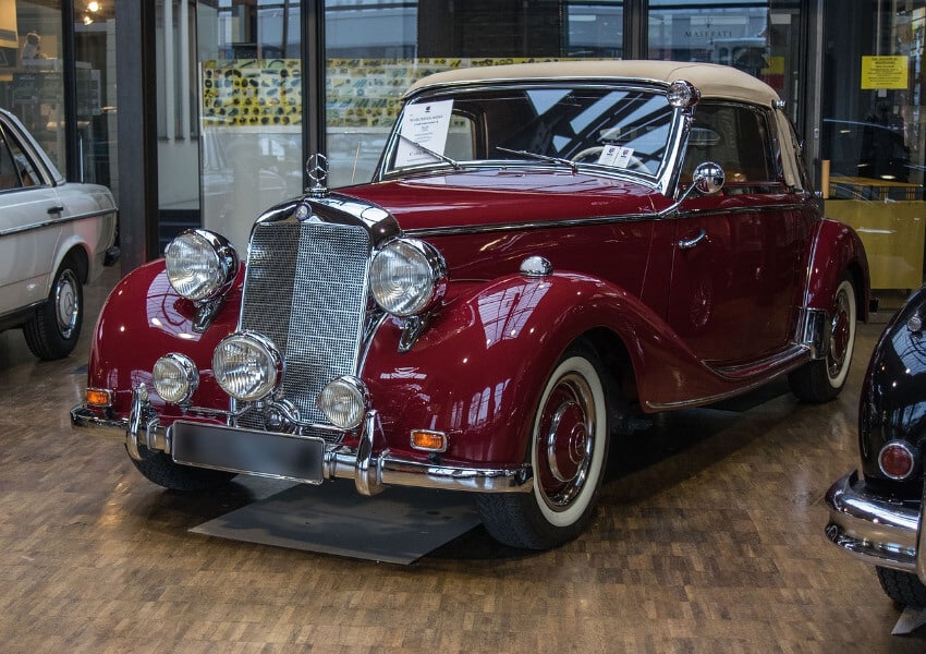 Ein weinrotes Mercedes Cabrio in einem Museum.